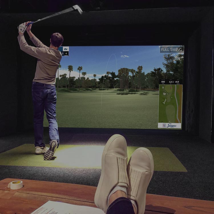 Man swinging golf club on Ames Golf Simulator